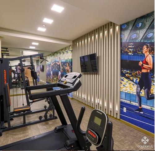 a gym with a woman running on a treadmill at Golden Lis Hotel Boutique in Goiânia