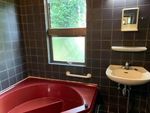 a bathroom with a red tub and a sink at Holyday House Nagata - Vacation STAY 07980v in Nagata