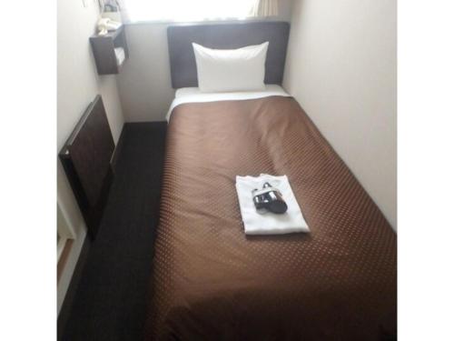 a small bedroom with a bed with a camera on it at Hotel Suntargas Otsuka - Vacation STAY 08494v in Tokyo