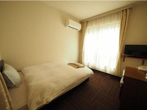 a hotel room with a bed and a window at Urbanty Nishikujo - Vacation STAY 08577v in Osaka