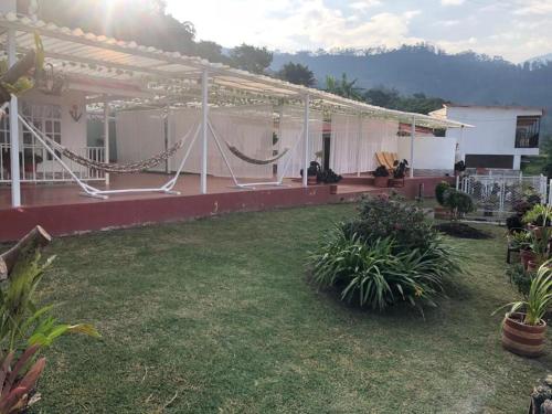 a house with a hammock in a yard at TARAHARA salud y bienestar in Santandercito