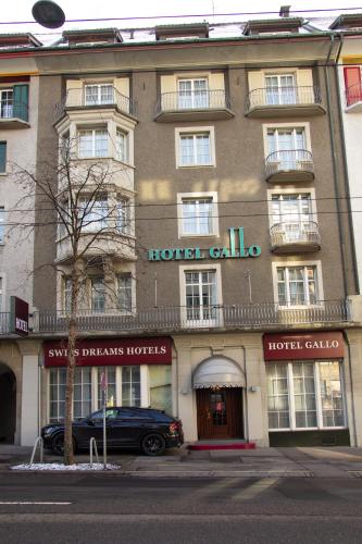 a hotel building with a car parked in front of it at Boutique City Hotel Gallo in St. Gallen