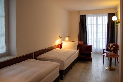 a hotel room with two beds and a window at Boutique City Hotel Gallo in St. Gallen