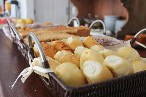 a basket of bread and pastries on a table at Pousada Tartaruga in Búzios