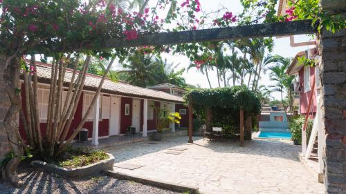 an archway leading to a house with a swimming pool at Pousada Tartaruga in Búzios