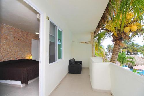 a bedroom with a bed and a palm tree at Bon Jesus Hotel in Costa Esmeralda