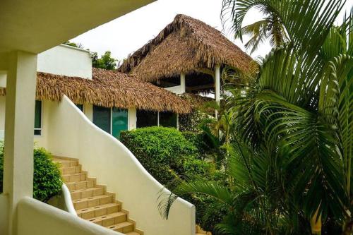 ein Gebäude mit einer Treppe, die zu einem Gebäude mit Strohdach führt in der Unterkunft Bon Jesus Hotel in Costa Esmeralda