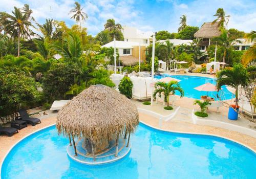 uma piscina com um guarda-sol de palha e um resort em Bon Jesus Hotel em Costa Esmeralda