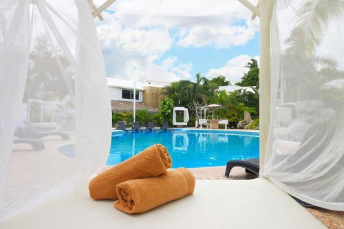 a towel sitting on a bed in front of a pool at Bon Jesus Hotel in Costa Esmeralda