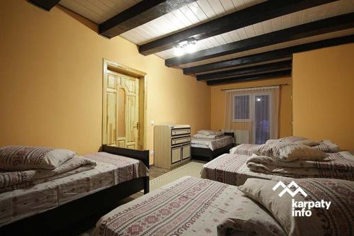 a room with three beds and a dresser at Гiрська Роса in Pilipets