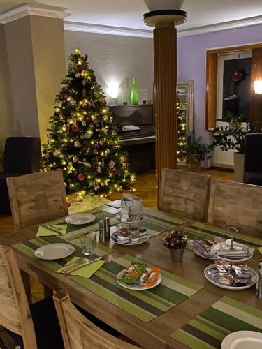 a table with a christmas tree in a living room at Hotel Sonnenhof in Sindelfingen