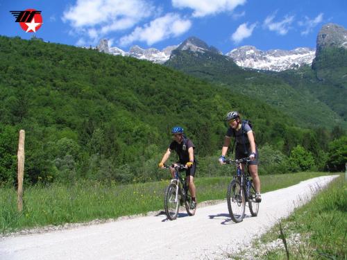 dos personas montando bicicletas en un camino de tierra en Hotel Alp, en Bovec