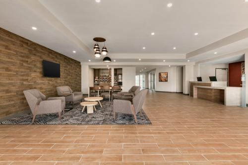 a lobby with chairs and tables and a brick wall at Candlewood Suites Fayetteville Fort Bragg by IHG in Fayetteville