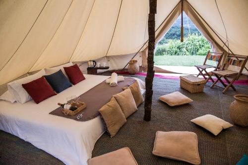 a tent with a bed in a room at Glamping Finca Corazón in Arcabuco