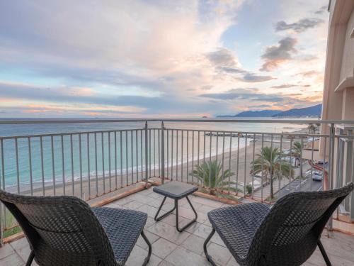 a balcony with chairs and a view of the beach at Hotel Jolly Roger in Pietra Ligure