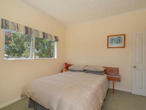 a bedroom with a bed and a window at Harbour View Haven - Pauanui Holiday Home in Pauanui