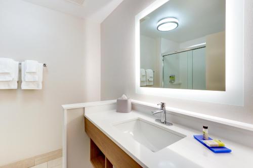 uma casa de banho branca com um lavatório e um espelho em Holiday Inn Express & Suites - Middletown - Goshen, an IHG Hotel em Middletown
