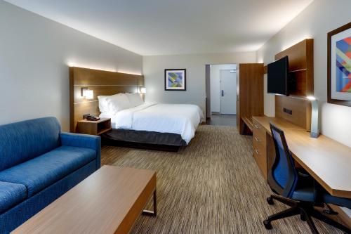 ミドルタウンにあるHoliday Inn Express & Suites - Middletown - Goshen, an IHG Hotelのベッドとソファ付きのホテルルーム