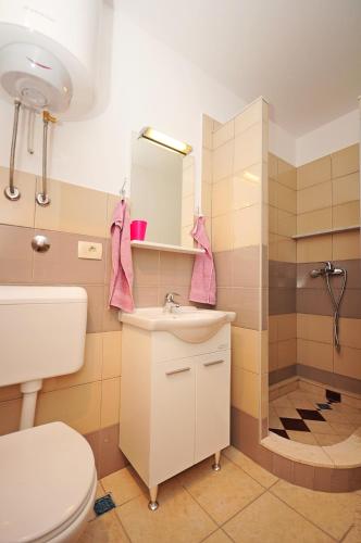a bathroom with a toilet and a sink and a shower at Apartman MAKA in Kučiće