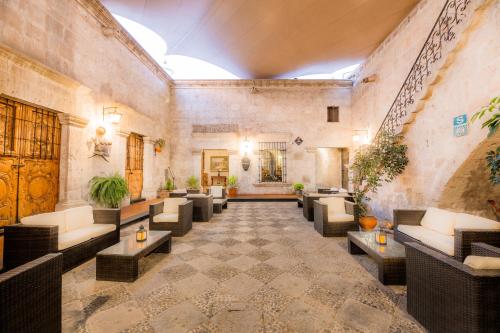 a lobby with couches and tables in a building at Hotel Los Tambos Colonial in Arequipa