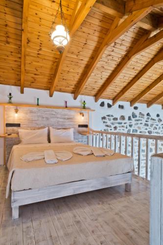 a large bed in a room with a wooden ceiling at Villa Anastasia in Voládha