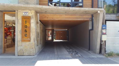 an entrance to a building with a sign on it at UMAIN KAYU in San Martín de los Andes
