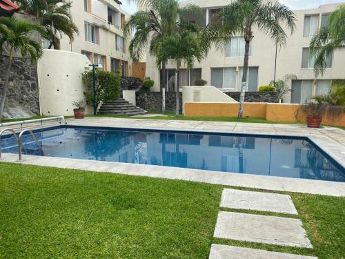 a swimming pool in a yard with a building at Casa en Oasis en Xochitepec in Chiconcuac