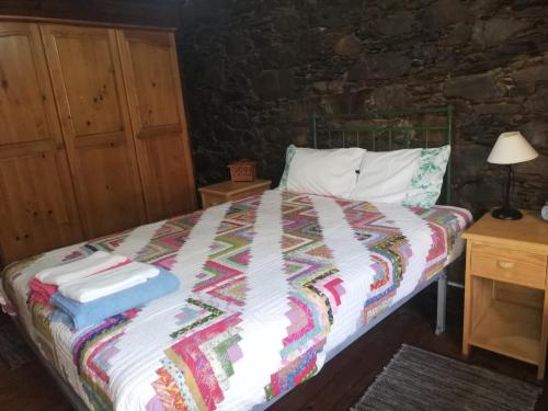 a bedroom with a bed with a colorful blanket at Casa das Tias in Lousã