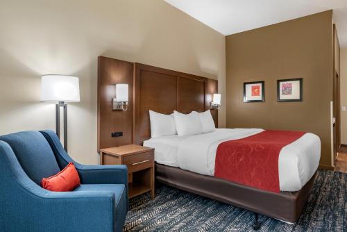 a hotel room with a bed and a chair at Comfort Inn & Suites Downtown near University in Tuscaloosa