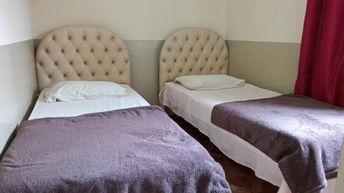 two beds sitting next to each other in a room at Vitória Center Plaza Praça in Nova Friburgo
