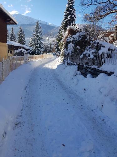 a road covered in snow next to a fence at Casa Reit in Bormio