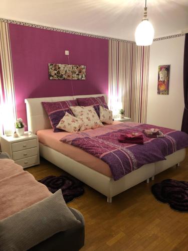 1 dormitorio con 1 cama grande y paredes moradas en Haus Zissi, en Burg-Reuland