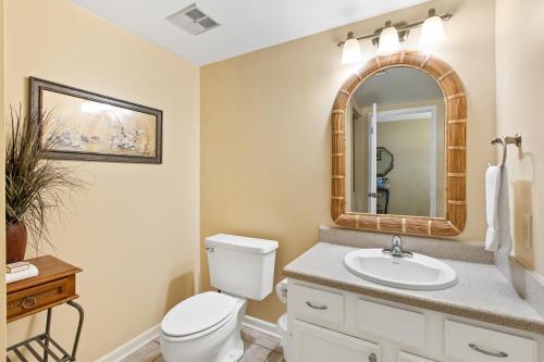 a bathroom with a toilet and a sink and a mirror at Peach Seashell in Destin
