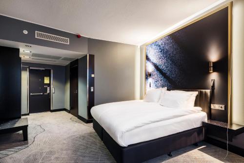 a bedroom with a large white bed in a room at Crowne Plaza Helsinki - Hesperia by IHG in Helsinki