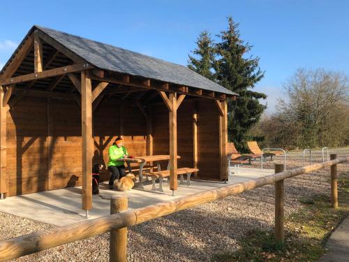 a man standing in a wooden pavilion with a table at Haus Zissi in Burg-Reuland