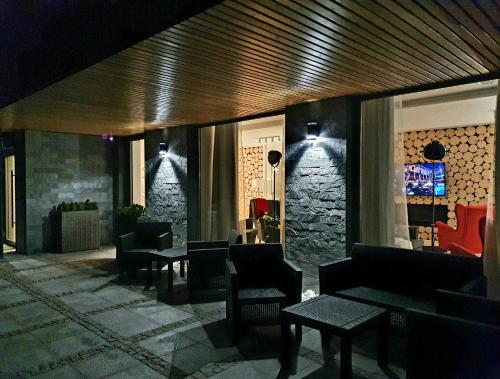 a lobby with tables and chairs and a stone wall at Villa Olimpijska 2 - Centrum in Wisła