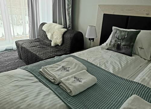 a bedroom with a bed with two towels on it at Villa Olimpijska 2 - Centrum in Wisła
