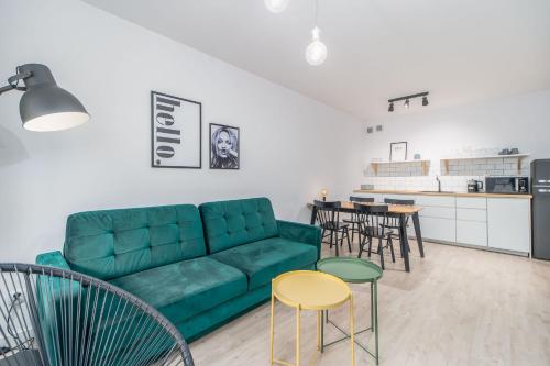 コウォブジェクにあるFARO Apartamenty Bliżej Morzaのリビングルーム(緑のソファ、椅子付)
