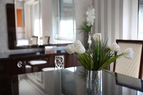 キシュケーレシュにあるPetra Apartmanのテーブルの上に白い花瓶