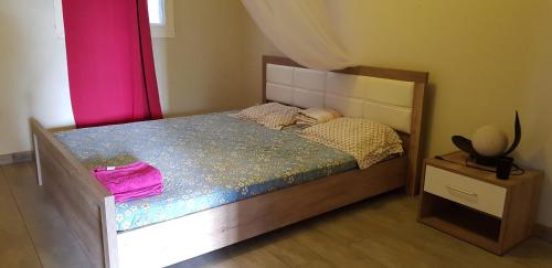 1 dormitorio con 1 cama con marco de madera en Joli F3 à une minute de la plage en Bouéni