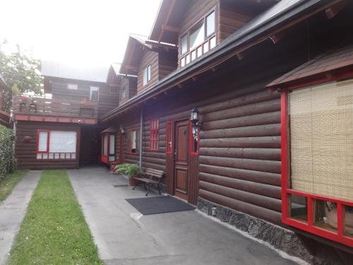 a building with red doors and a bench next to it at B&B HMüller in Pucón