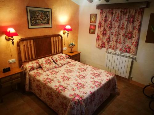 1 dormitorio con 1 cama, 2 lámparas y ventana en Cortijo Los Soledad en El Sauco