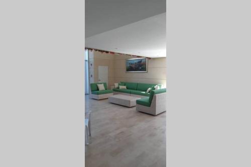 a living room with a green couch and a table at Velas Al Mar - Apartamento Rodadero Gaira in Gaira