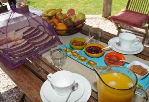 a picnic table with food and a bowl of fruit at La Maison Suites & Gastronomía in La Paloma
