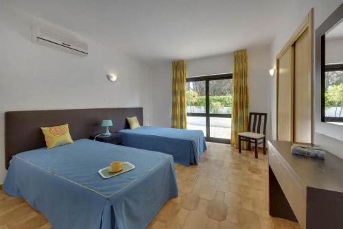 a hotel room with two beds and a television at VILLA COELHO in Albufeira