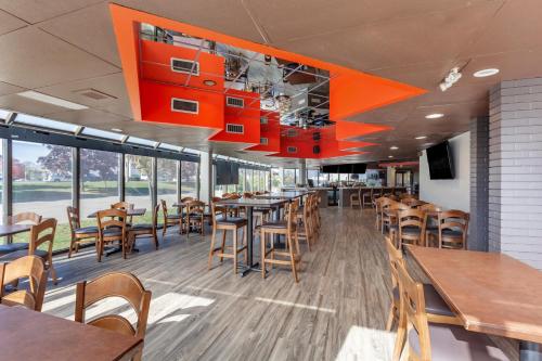 a restaurant with wooden tables and chairs and windows at Comfort Inn Airport West in Mississauga