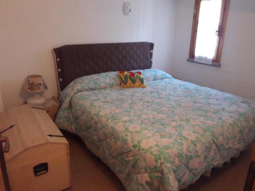 a bedroom with a bed and a wooden nightstand at Abetone - Parco dei Daini in Abetone