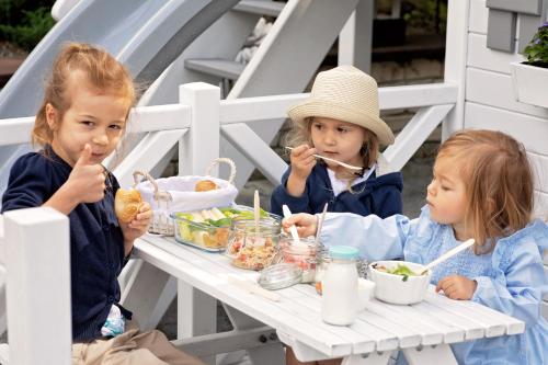 two little girls sitting at a table eating food at Górska Legenda Apartamenty & Domki in Szczyrk