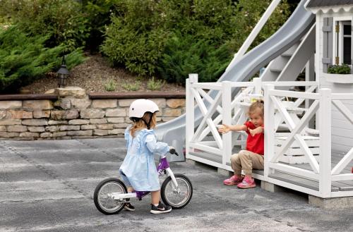 two little girls playing with a bike on a bridge at Górska Legenda Apartamenty & Domki in Szczyrk