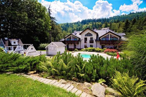 a house with a swimming pool in a yard at Górska Legenda Apartamenty & Domki in Szczyrk